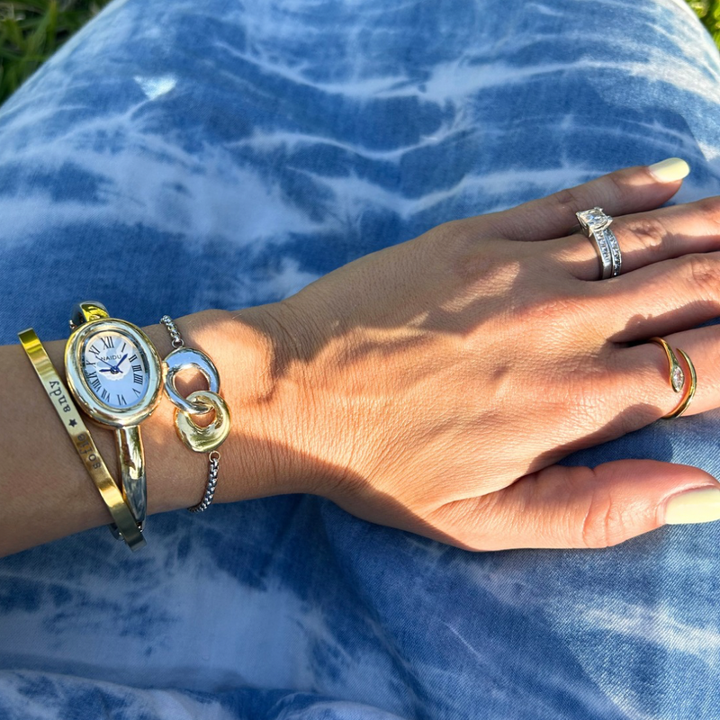 Two-tone gold and silver interlocking link bracelet on a delicate silver box chain worn on wrist