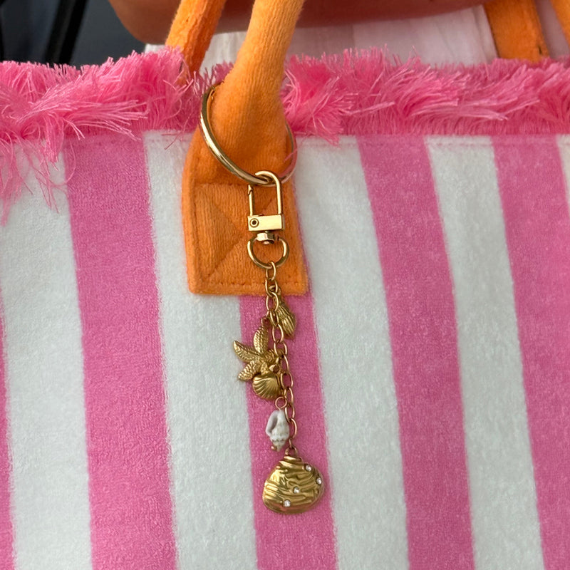 Gold coastal bag charm keychain with starfish seashell baroque pearl and engraved coin charm on a carabiner clip