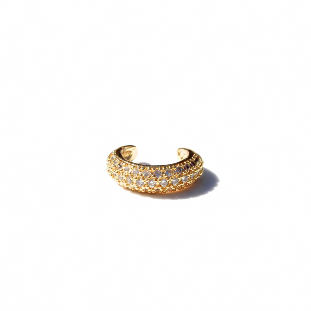 A white zircon ear cuff with gold plating on stainless steel, displayed on a white background.