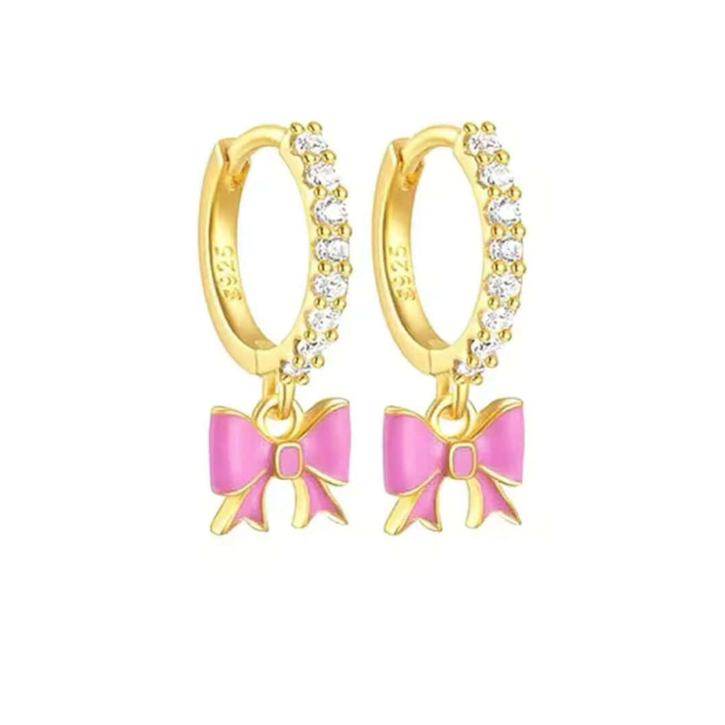 Gold hoop earrings with pink bow charms on a white background