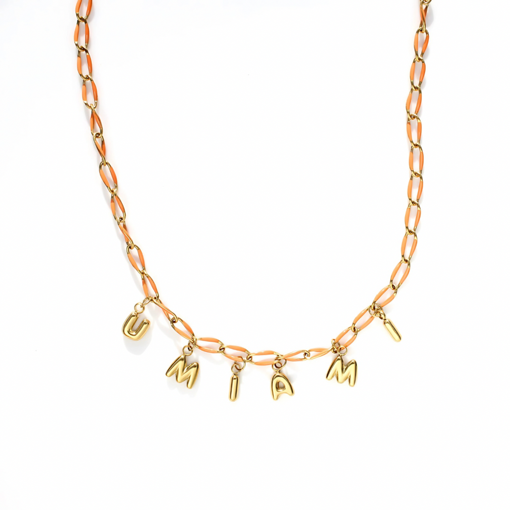 Gold necklace with letter charms on a white background