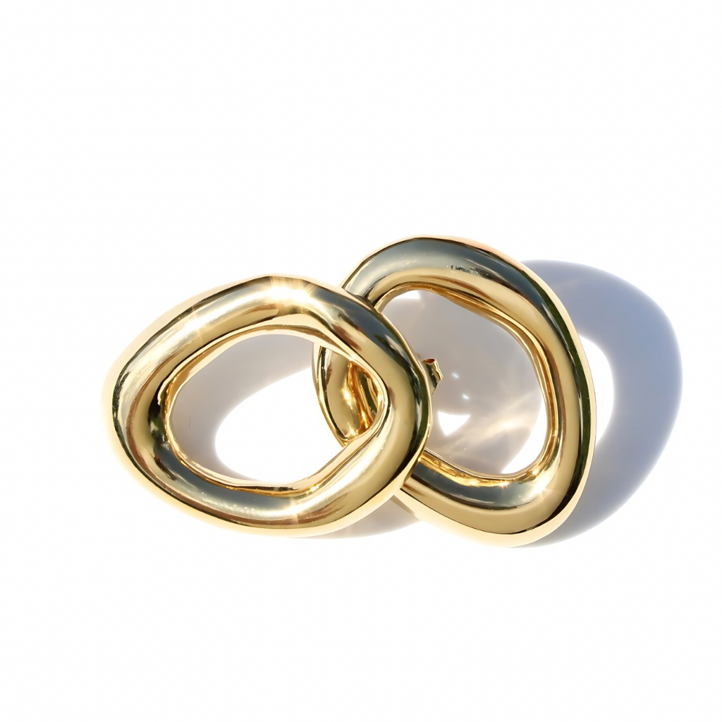 Pair of gold statement rounds earrings on a white background