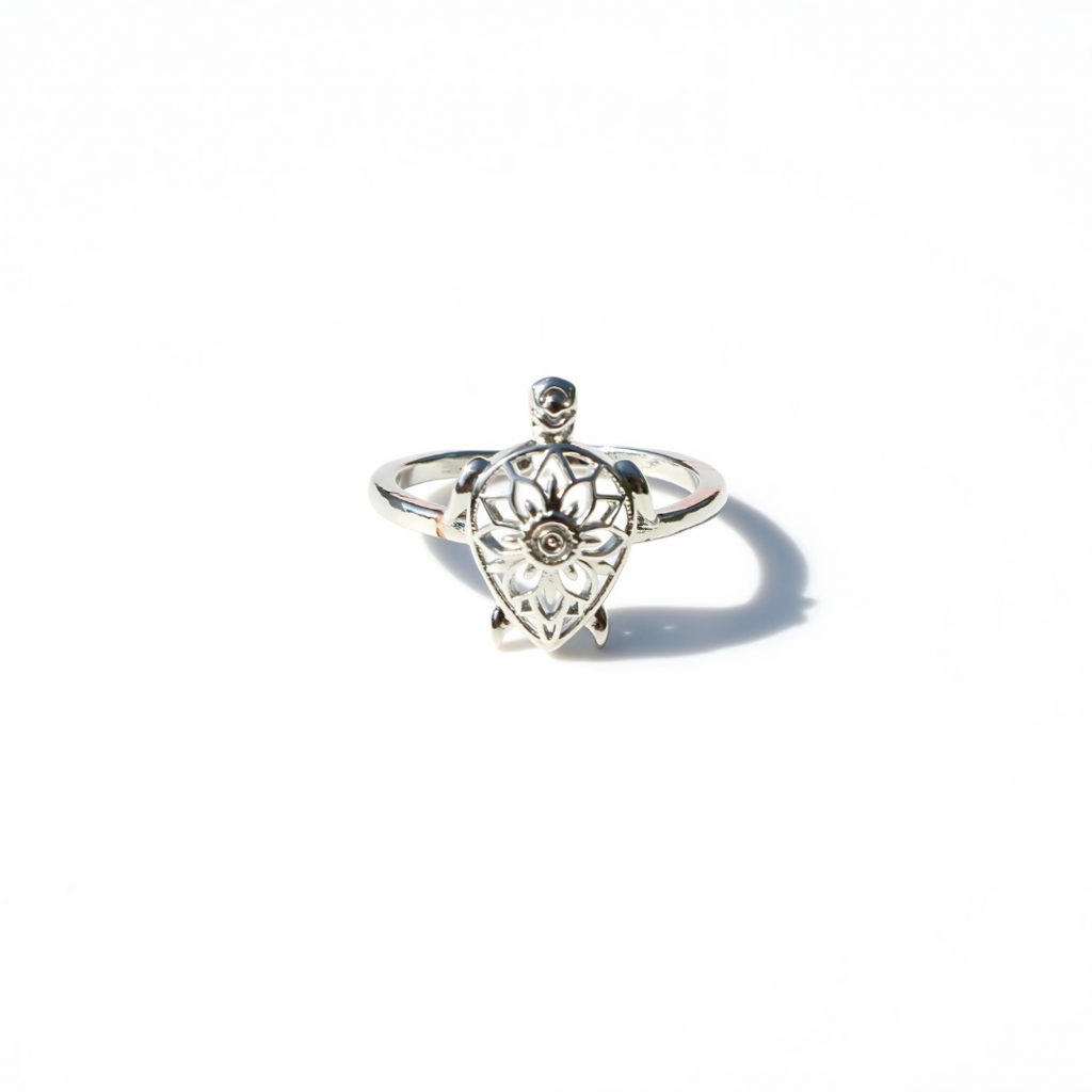 Silver ring with intricate design of a turtle on a white background