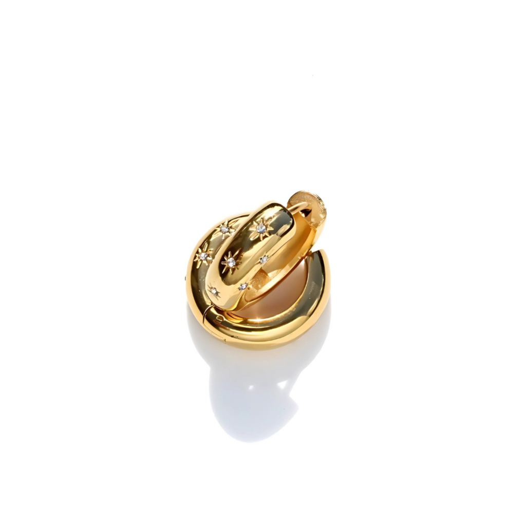 Gold huggie earrings with star design on a white background
